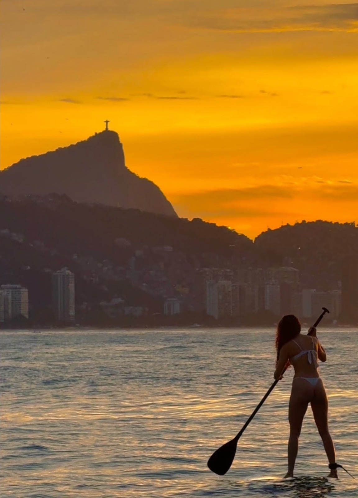 Stand up paddle ao entardecer com o Cristo Redentor ao fundo